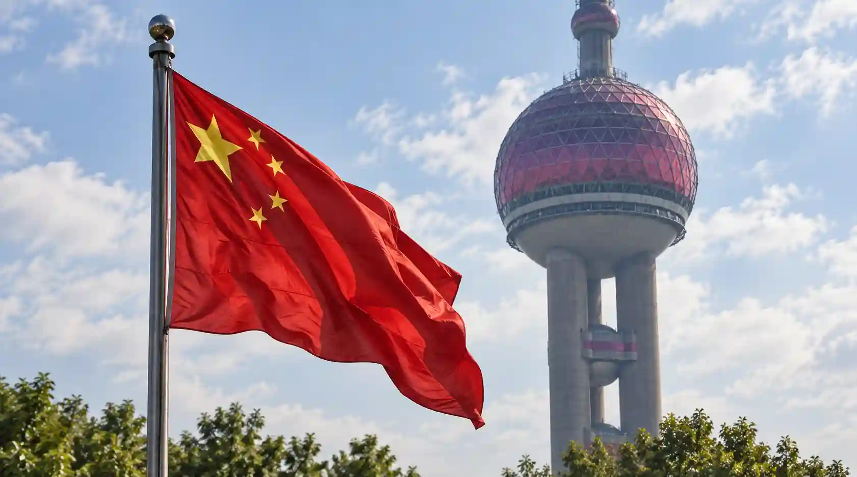 A conceptual image showing the flags of the US and China over a background of computer chips and AI networks.