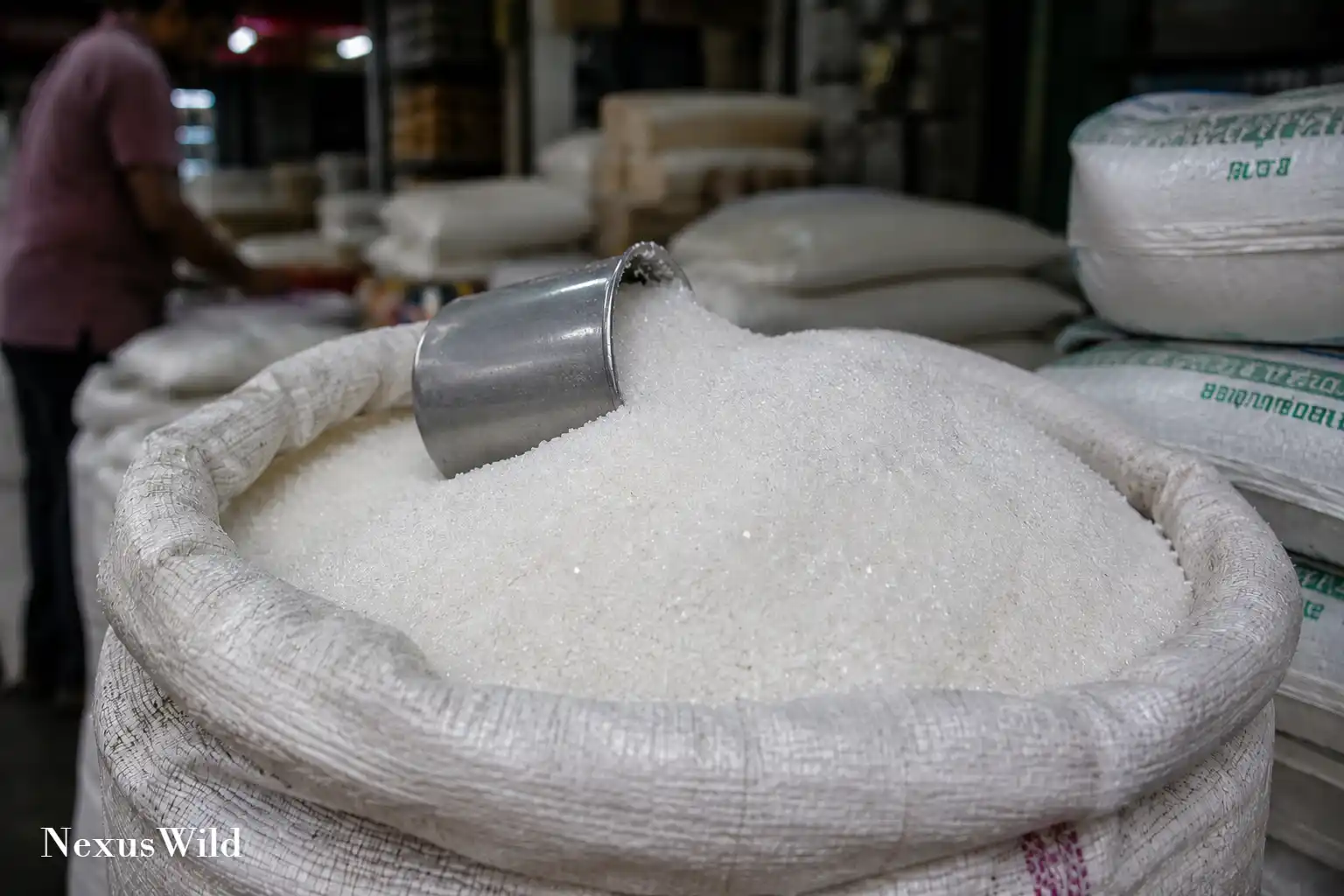 Bags of refined white sugar stacked in an Indian wholesale market.