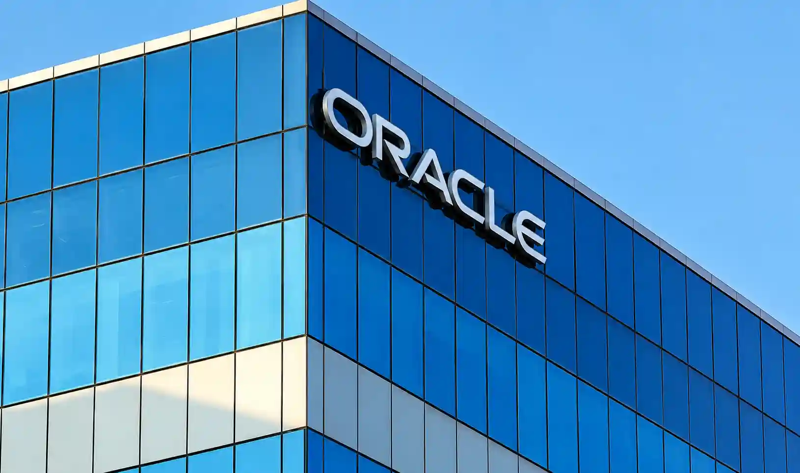 The exterior glass facade and corporate signage of an Oracle office building