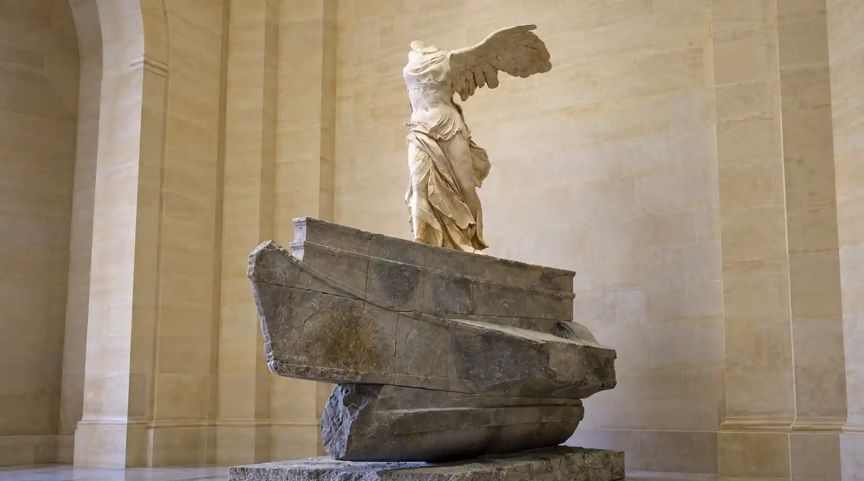 The Winged Victory of Samothrace standing at the top of the Daru staircase in the Louvre Museum.